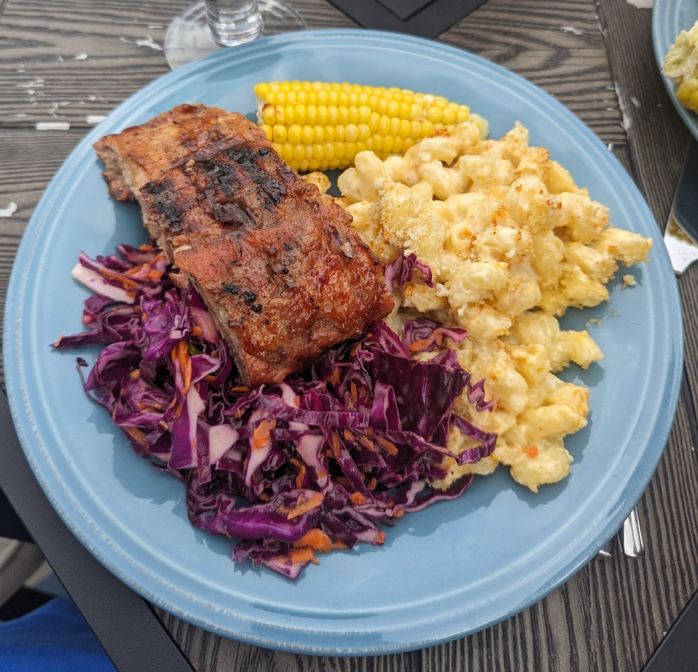 Plate with mac and cheese, corn on the cob, barbecue ribs, and slaw